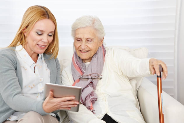 nurse helping senior with online shopping